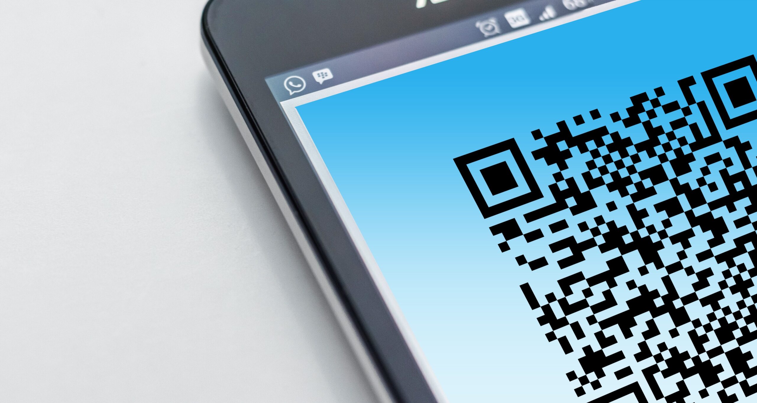 Close-up of a smartphone displaying a QR code for a contactless restaurant menu.